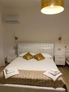 a bedroom with a white bed with gold pillows at Le Margherite in Montesilvano