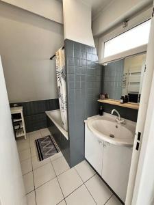 a bathroom with a sink and a tub and a mirror at Appartement paris Disneyland in Bussy-Saint-Georges