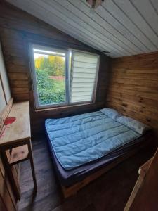 a small bedroom with a bed in a cabin at Apartament HOLENDER na Polu namiotowym RADOŚĆ in Okuninka