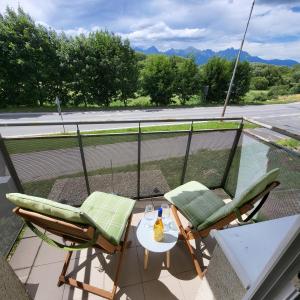 a balcony with two chairs and a table with a bottle at Tatry Mountain Paradise in Poprad