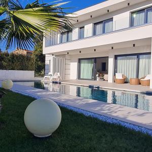 a house with a swimming pool in front of it at Luxury Villa Milly Heated indoor and outdoor pool in Vrh