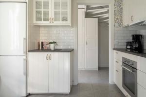 a white kitchen with white cabinets and appliances at Lovely 2 bedroom apartment in Visby in Visby +10 photos