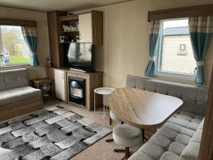 a living room with a table and a couch at A fully equiped caravan Marton mere haven in Blackpool