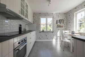 a kitchen with white cabinets and a table and a window at Lovely 2 bedroom apartment in Visby in Visby