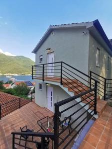 Casa con balcón y patio con mesa. en Stone Village Suite Kamenari, en Kamenari