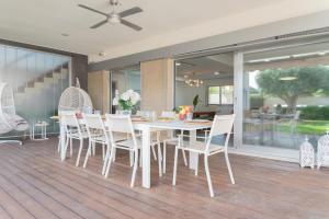 a dining room with a white table and chairs at Villa Helios Aguadulce Almeria in Roquetas de Mar