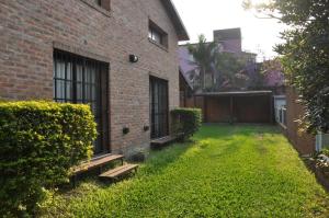 a yard of a brick building with a bench at Aya Bungalows in Colón