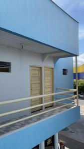 een blauw en wit gebouw met twee bruine deuren bij Pousada Andrade in Parnaíba