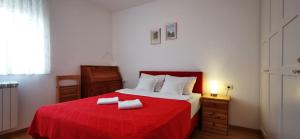 een slaapkamer met een rood bed en 2 handdoeken erop bij Brand New Place in Rovinj