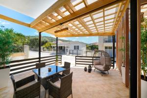 un patio al aire libre con pérgola de madera en Aesthesis Luxury Retreat, en Skala Sotiros