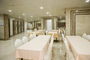 a banquet hall with white tables and white chairs at Mahd Al Resala 3 Hotel in Mecca