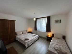 a room with two beds and a window at Къща Цвети in Dobrinishte