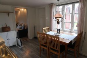 a dining room table with chairs and a chandelier at Lillehuset in Kabelvåg