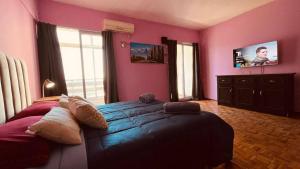 a bedroom with pink walls and a large bed at Black Sheep International Hostel in Mendoza