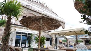 Un patio con sillas y sombrillas frente a un edificio. en Hotel Laura, en Velipojë
