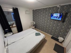 a bedroom with a bed and a tv on a wall at Bakgården Mariestad in Mariestad