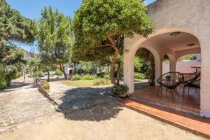 an outdoor patio with a tree and a table at Villino in Torre delle Stelle