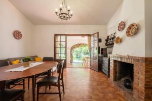 a dining room with a table and a fireplace at Villino in Torre delle Stelle