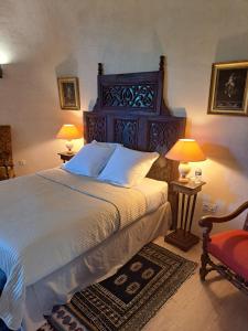 a bedroom with a bed with two lamps and a chair at Chateau de Sainte Jalle in Sainte-Jalle +28 photos