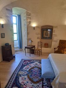 a bedroom with a bed and a table and chairs at Chateau de Sainte Jalle in Sainte-Jalle