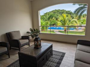 a living room with a large window and a coffee table at Casa Paraiso in Nuevo Vallarta 
