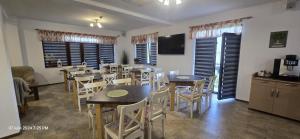 ein Esszimmer mit Tischen und Stühlen und eine Küche in der Unterkunft Donaris in Eşelniţa