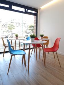 a dining room with tables and colorful chairs at Bilbao ROOMS & KITCHEN Santutxu in Bilbao +35 photos