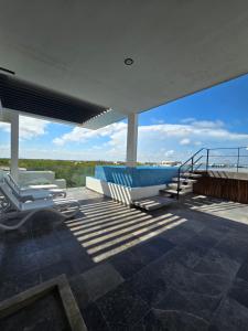 una casa con piscina e sedie sul tetto di Cozy Studio Aldea Zama Tulum WIFI Alberca a Tulum