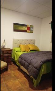 a bedroom with a bed with yellow pillows on it at Cabañas KAPO TEAM in Villa Amancay