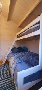 a bedroom with two bunk beds in a wooden room at Sea breeze Apšuciems in Apšuciems
