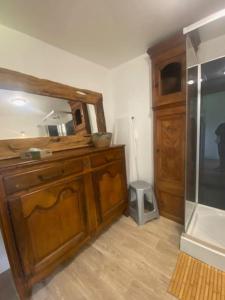 a bathroom with a wooden cabinet and a mirror at Le Domaine Des Roses Normandie Foulognes in Foulognes