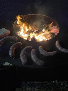 a bunch of sausages cooking on a grill at Le Domaine Des Roses Normandie Foulognes in Foulognes