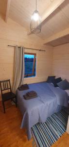 a bedroom with a blue bed and a window at Sea breeze Apšuciems in Apšuciems +29 photos