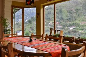 a dining room table with a view of a mountain at La Casa Verde Eco Guest House in Baños