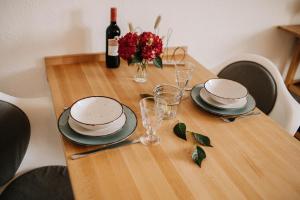 a table with plates and glasses and a bottle of wine at Gemütliches Appartement für 2 in Siegen