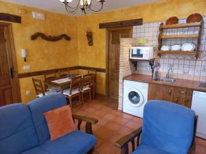 a kitchen with blue chairs and a table and a microwave at Casas Rurales Mi Reja A in Santa María de Riaza