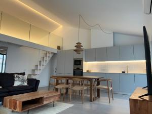 a kitchen and living room with a table and a couch at Casa Furnas in Carrapateira