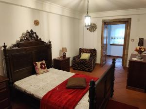 a bedroom with a large bed and a chair at Casa da Avó in Cetos