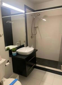 a bathroom with a sink and a shower with a mirror at Rest in Vegas in Las Vegas