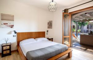 a bedroom with a bed and a sliding glass door at Agriturismo La Sassicaia in Castiglione della Pescaia