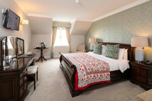 a bedroom with a bed and a dresser and a mirror at Schull Harbour Hotel & Leisure Centre in Schull