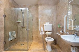 a bathroom with a shower and a toilet and a sink at Schull Harbour Hotel & Leisure Centre in Schull