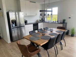 a kitchen with a table with chairs and a refrigerator at Skógar Lodge in Hvolsvöllur