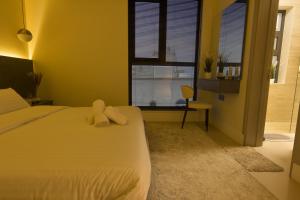 een slaapkamer met een bed met twee knuffels erop bij Modern Luxurious 1BR, Penthouse BLISS in Seeb