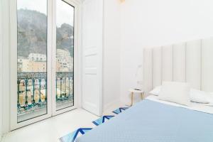 a bedroom with a bed and a large window at Palazzo Colavolpe in Atrani