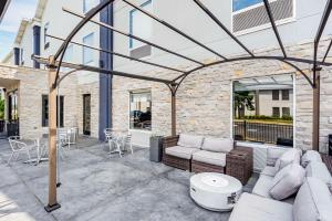 a patio with couches and a table and chairs at Best Western Plus Bourbonnais Hotel & Suites in Bourbonnais
