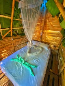 a bed with a snake laying on top of it at Green House Chalé, hostel e pousada in Saquarema