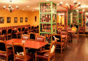 um restaurante com mesas e cadeiras num quarto em Nativo Lodge em Albuquerque