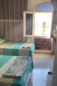 two beds in a room with a window at شالية للايجار فارما بيتش ريزورت in Al Ḩammād +8 photos
