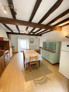 una grande cucina con tavolo e frigorifero di Domaine de Lann Kerhuerh a La Chapelle-Neuve